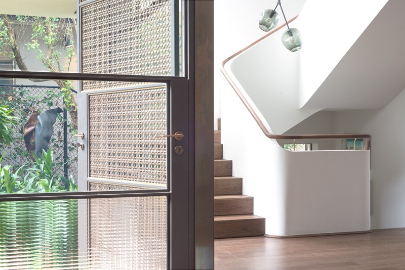 light filled stairwell and woven brass entry door Light Filled Stairwell, Woven Brass Mesh, Timber Balustrade