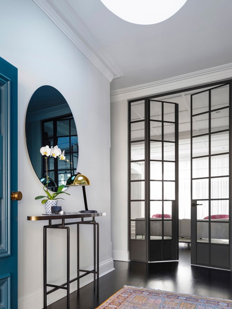 Luigi Rosselli Architects | Interior design with steel doors, blue mirror, gold lamp and dark timber floorboards