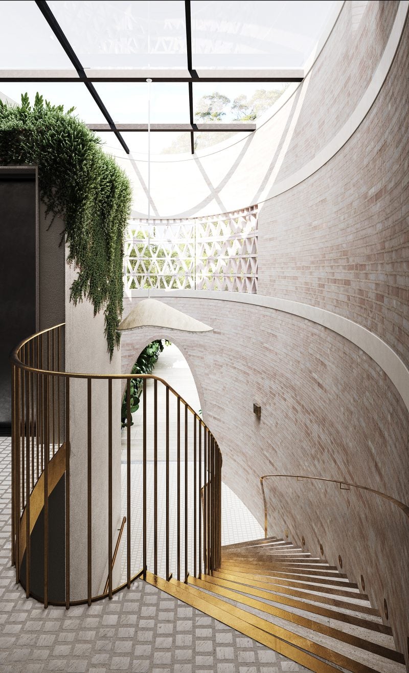 The central stairs, detailed with gold handrail and trim, swoops along the curved brick walls of the lobby, scrapa travertino classico flooring