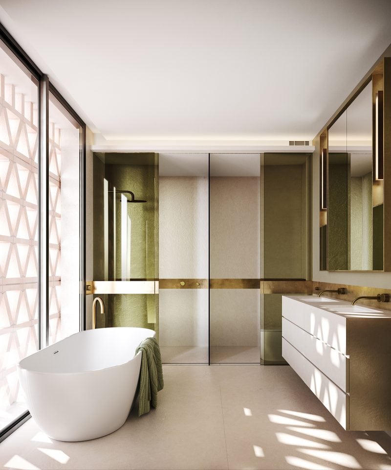 Olive-tinged Shower screens, brass hardware, porcelain freestanding bath beside the full length window, shielded from the outsider gaze by brick brise soleil screen