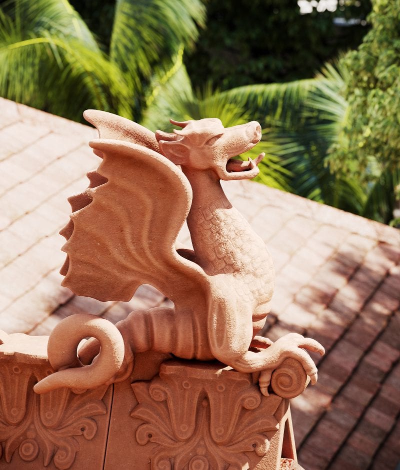 a detailed terracotta dragon finial perched on an ornamented roof ridge