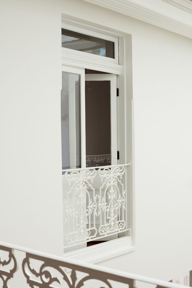 Once opening onto the exterior, an existing window with its original filigree balustrade and swing window now looks down onto the new atrium