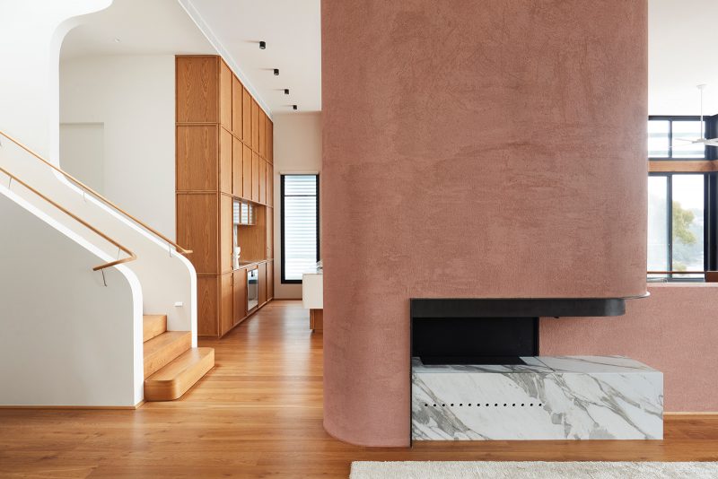 Luigi Rosselli, pink rammed earth, reminiscent of Casa Malaparte, curves around the white marble and black steel frame of the modern fireplace