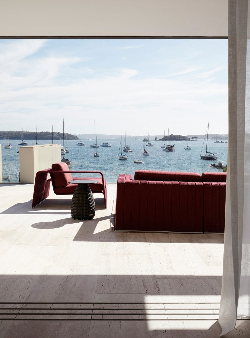 Luigi Rosselli, outdoor sofa set in red on a travertine terrace, overlooking sailboats in the blue Sydney habour on a lovely day