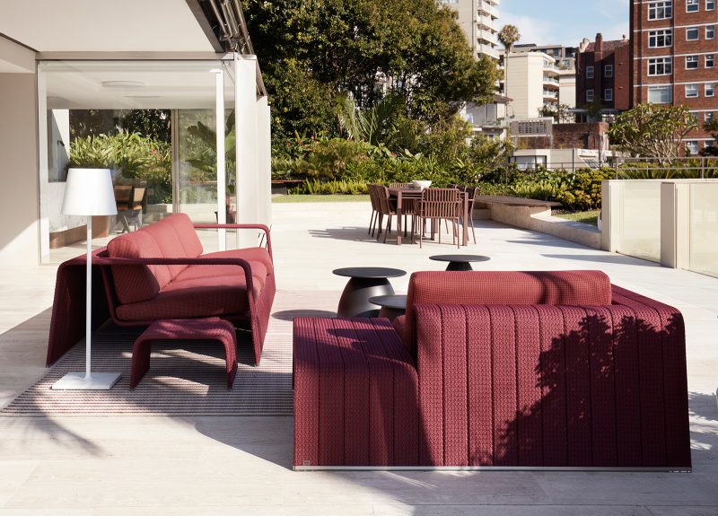 Luigi Rosselli, two outdoor sofa in red on a travertine landscaped terrace, partially under the shade on the roof