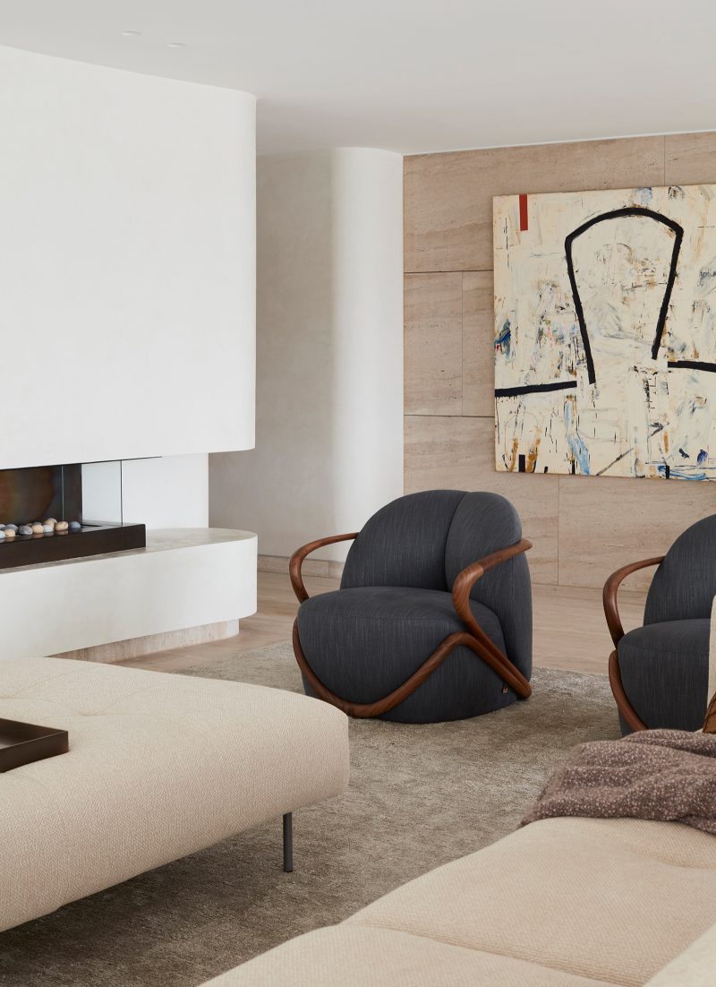 Luigi Rosselli, a restrained living room design with a neutral palate, with a modern curved fireplace