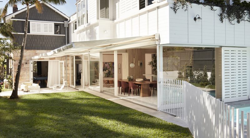 white timber rear addition, large sliding doors connect the living and dining room to the garden, awnings and sliding shutters shades the spaces