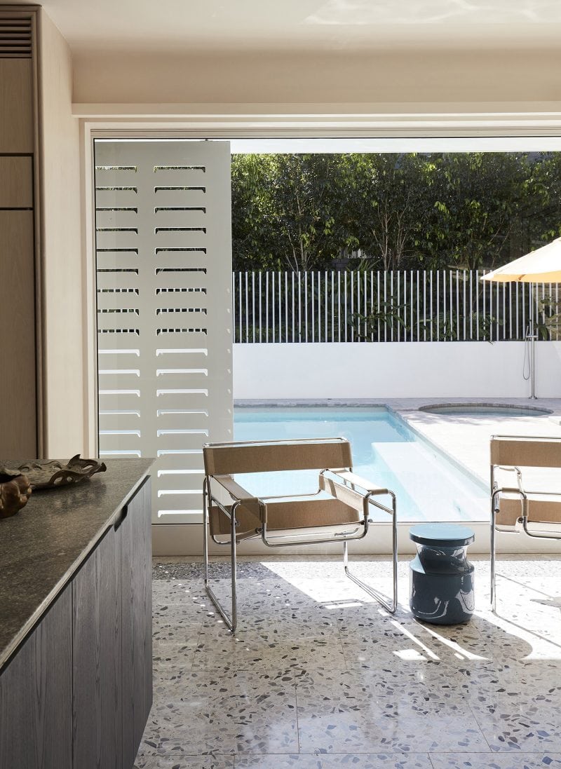white sliding shutters shades the dining room, terrazzo tiles